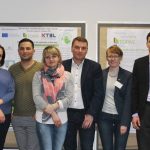 Gruppenbild der 13 Teilnehmer in einem Saal mit Plakaten zwischen ihnen Prof. Schlauderer