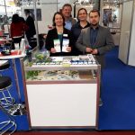 Vier Personen hinter einem Stand mit Flyer