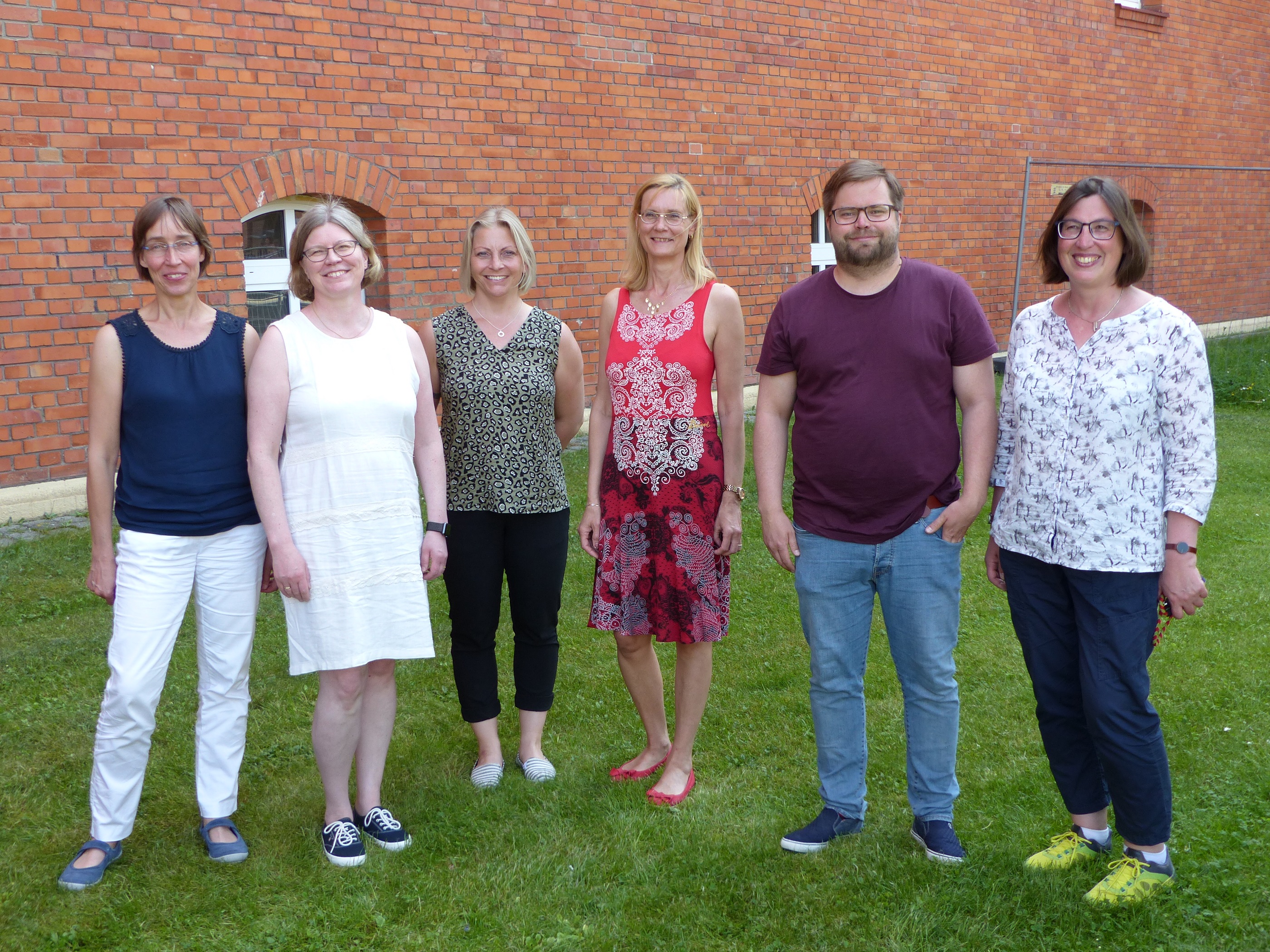 Gruppenbild der finnischen Gäste draußen auf einer Wiese