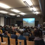 Die zwei Redner im vollen Hörsaal