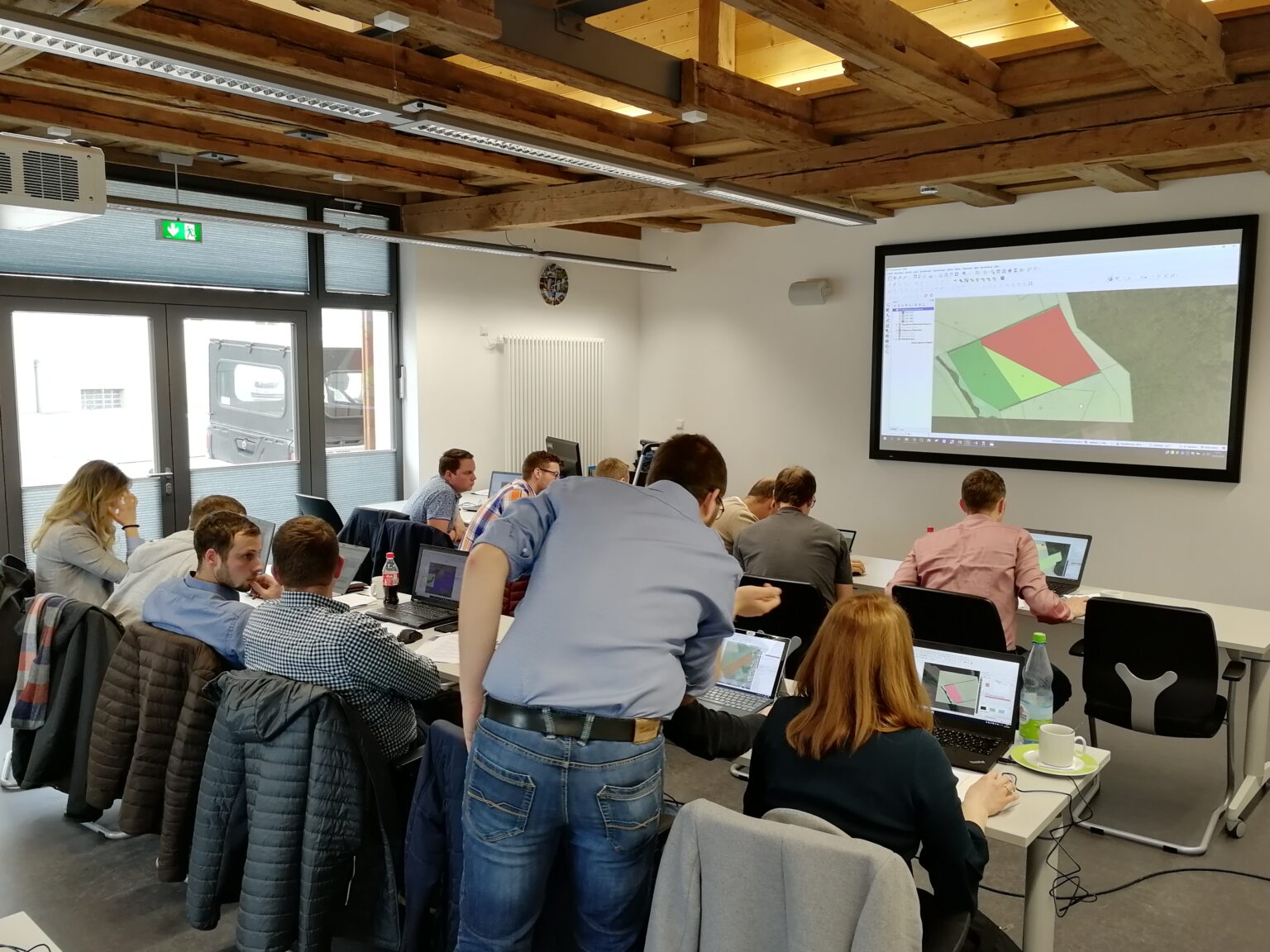 Auf dem Bild ist eine Gruppe während einer Schulung in einem Schulungsraum zu sehen.