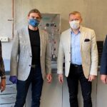 Die drei Männer und eine Frau haben eine Maske auf.