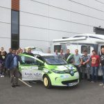 Um das grüne Forschungsauto aus Ansbach sind jede Menge Menschen (18) versammelt, die Türen vorne und der Kofferaum stehen offen