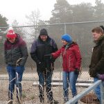 Die Dozentin erklärt etwas den außenrumstehenden Studenten, der Kleidung zur Folge scheint es Winter zu sein