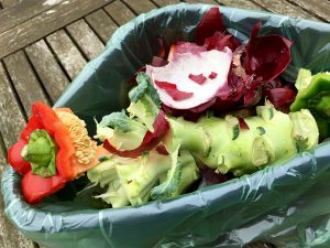 Frischer Biomüll mit Paprika und Kohl in einer kleinen Plastikschüssel